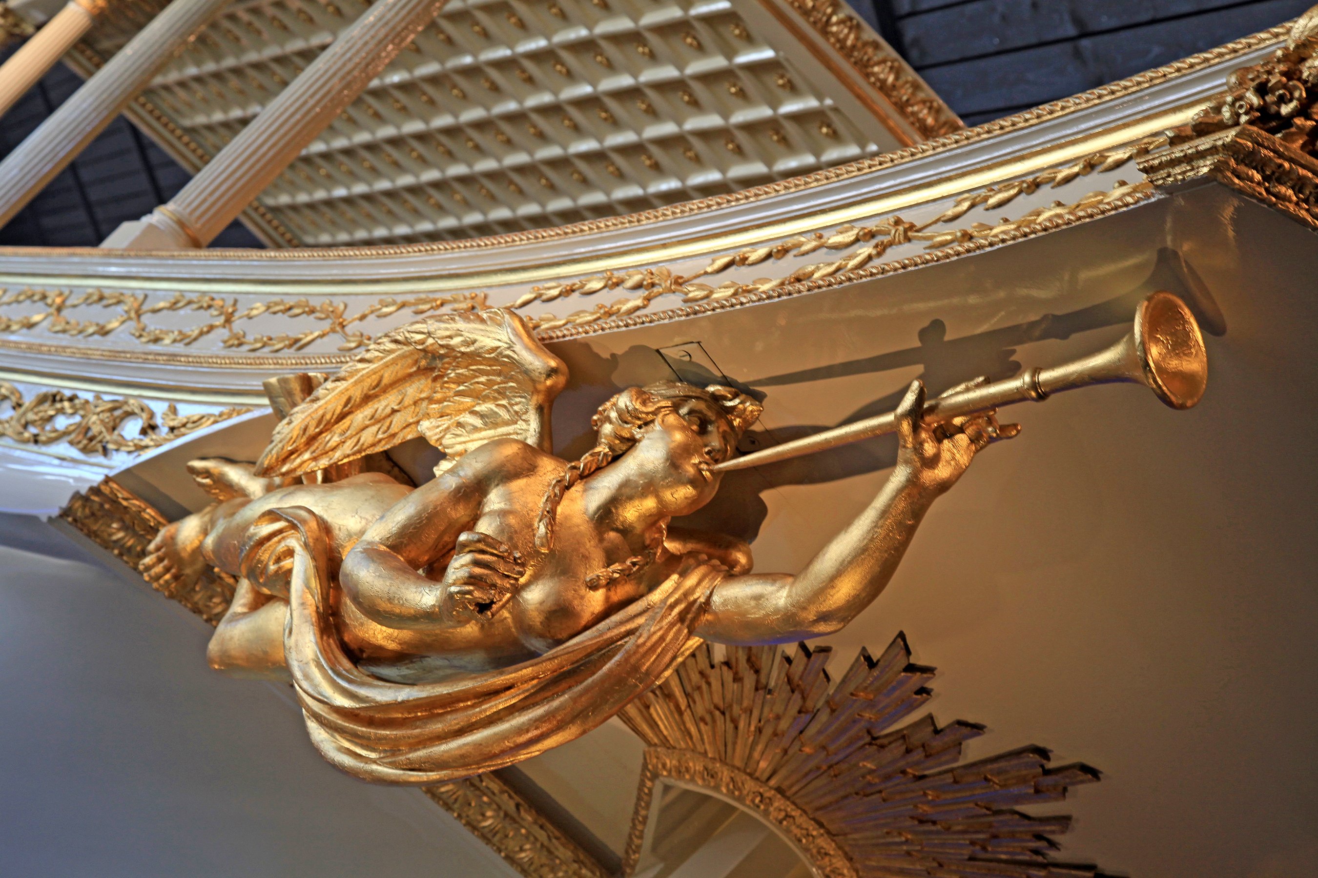 Gold baroque angel statue blowing a trumpet