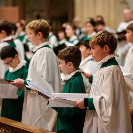 Group of boy choristers standing and singing in Bath Abbey